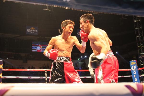 角谷 淳志選手が相手選手の右頬に左手パンチをしている写真